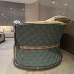 Cream Curved Leather Sofa with Dark Green Fan-Stitched Panels and Laced Edge Details